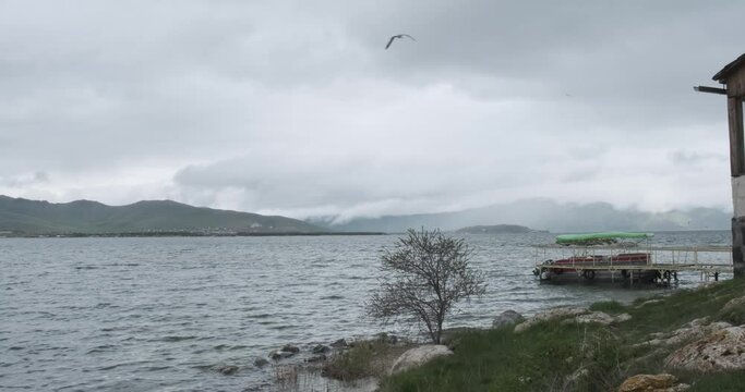 Capture the ethereal beauty of the serene lakeshore along the breathtaking Sevan Mountain Lake, where the atmosphere is charged with a sense of awe and wonder.