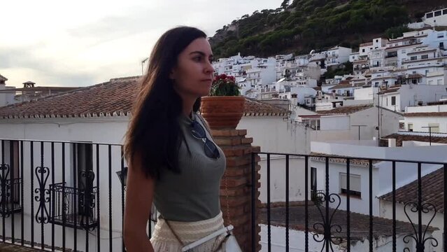 Close-up footage of young caucasian woman walking in typical spanish village. Slow motion.