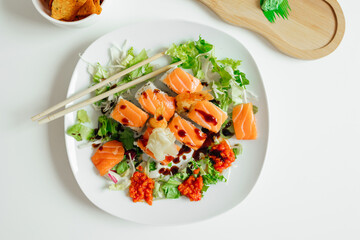Top view of fusion salmon sushi rolls with sauce on white plate. Healthy and fusion japanese food style concept
