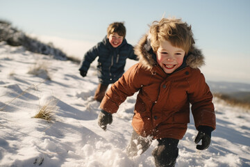 Fototapeta na wymiar two children enjoying themselves playing in the snow on top of a snowy hill