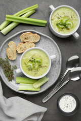 Delicious celery soup served on gray table, flat lay
