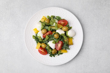 Delicious salad with pesto sauce on light table, top view