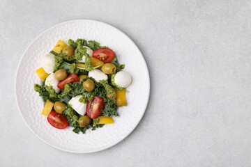 Delicious salad with pesto sauce on light table, top view. Space for text