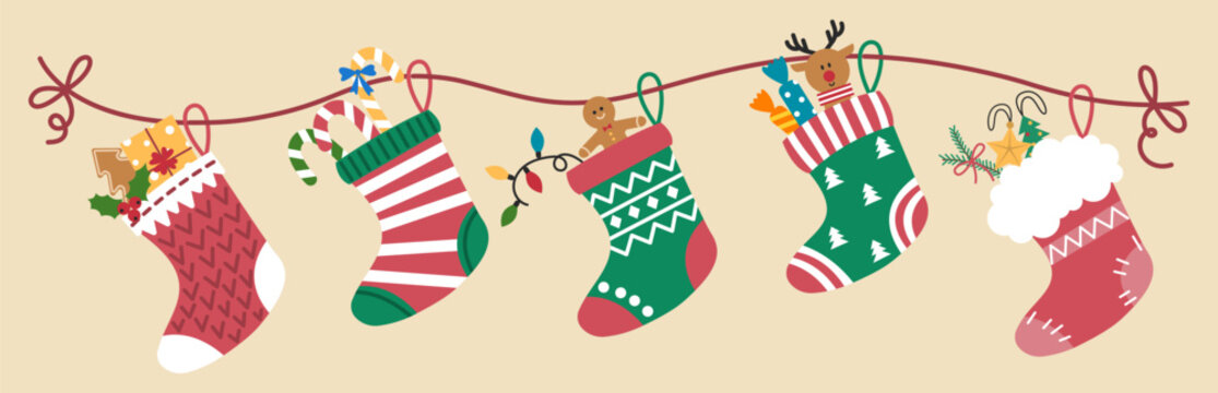 Christmas socks with gifts hanging on rope against light background