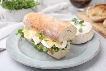 Tasty sandwich with brie cheese on light grey table, closeup