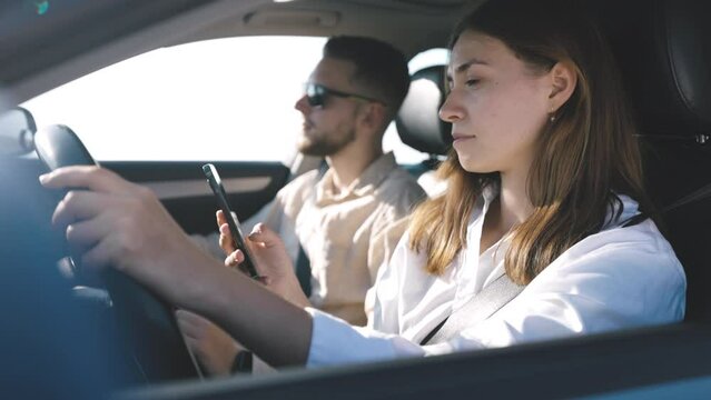 Woman driving distracted from road and scrolls feed of social media, phone addict looks news on Internet, angry man takes gadget from hands