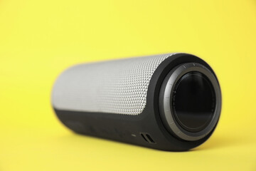 One portable bluetooth speaker on yellow background, closeup. Audio equipment