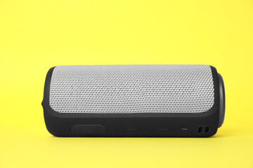 One portable bluetooth speaker on yellow background. Audio equipment