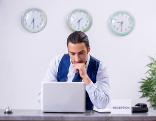 Young man receptionist at the hotel counter