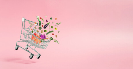 Various colorful vegetables coming out of shopping cart. Spring nature concept. Season background idea. Creative abstract concept. Pop art aesthetic with copy space for text.