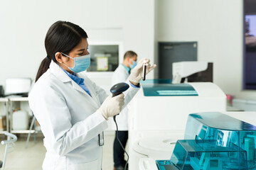Female chemist doing medical tests of blood samples