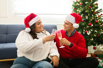 Obraz premium Mexican couple in love toasting with champagne on christmas