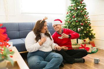 Cheerful couple getting engaged during christmas