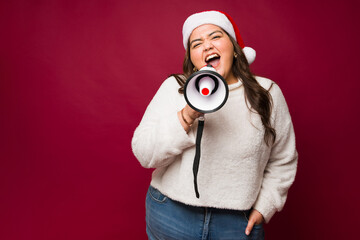 Fototapeta premium Happy obese woman screaming with a megaphone for christmas