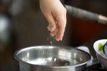 Close up of chef hands cooking in kitchen, shallow depth of field