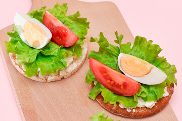 Rice Cake Sandwiches with Tomato, Lettuce and Egg on Wooden Cutting Board. Easy Breakfast. Diet Food. Quick and Healthy Sandwiches. Crispbread with Tasty Filling. Healthy Dietary Snack