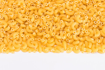 Uncooked Chifferi Rigati Pasta Scattered on White Table. Fat and Unhealthy Food. Classic Dry Macaroni. Italian Culture and Cuisine. Raw Pasta