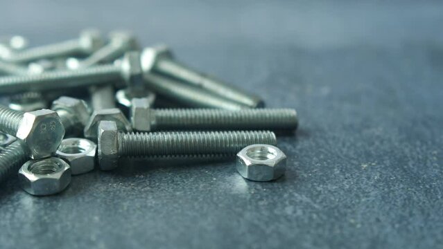 metal screw or bolt and nuts wooden background.