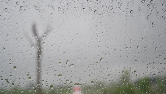 Rain Drops Falling down on background view, High quality photo of Rain on Window Sky Drops, Close up Slow Rain, Rainy day, Heavy Rainfall. Raining in car mirrors on traffic.