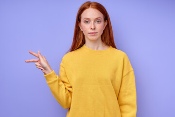 letter K spelling by girl's hand in American Sign Language (ASL) on blue background, closeup portrait, confident Caucasian woman demonstrating the letter K. sign language symbol for deaf human