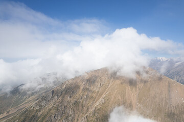 Aerial shot of mountain landscape into the clouds