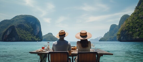 An Asian couple enjoys their honeymoon on a boat in Thailand relaxing eating seafood and exploring...