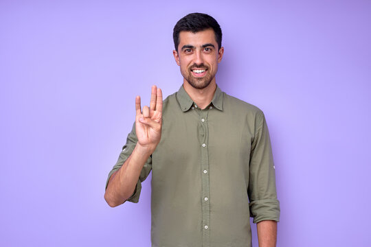 happy handsome smiling deaf mute man using sign language on blue background