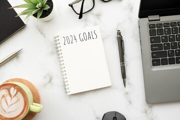 Notebook with 2024 goals text on it to apply new year resolutions and plan. - obrazy, fototapety, plakaty