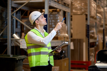 male worker doing stocktaking of product management on shelves in warehouse, counting and taking notes. Physical inventory count. Male professional assistant checking controlling the stock