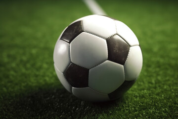 Fototapeta premium Soccer ball laying on the green grass of soccer field