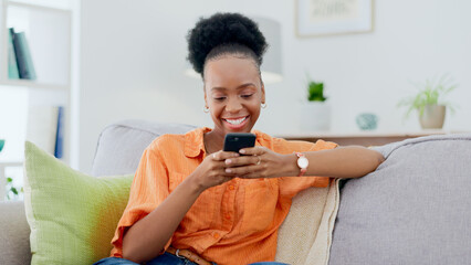 Smile, black woman and typing on smartphone on sofa, update social media post and mobile chat at...