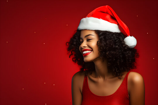 Happy black woman wearing Christmas hat isolated on red colour background