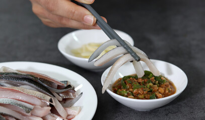 Close-up image of gizzard shad sashimi on plate.
