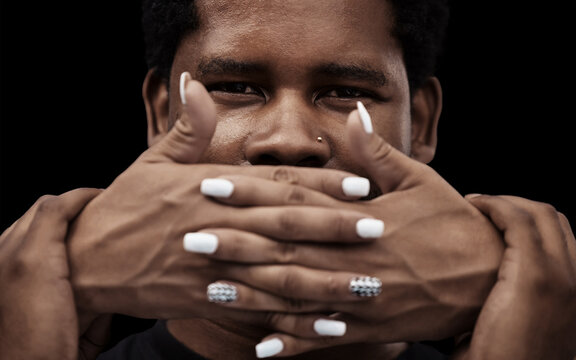 Hands, mouth and silence for man, victim or cover to stop freedom of speech for human rights by black background. African person, fear and quiet voice for oppression, censorship or racism in portrait