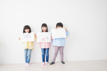Naklejka premium 自分で描いた絵を見せる小さな子どもたち