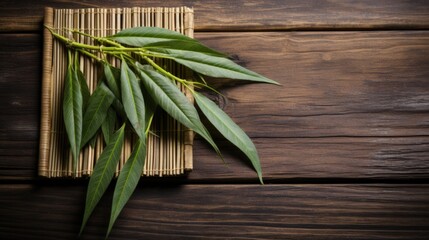 a green leaves on a bamboo mat - obrazy, fototapety, plakaty