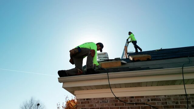 Roofer repair or replace shingle that has been damaged and needing replacement at sunny day Naperville IL. USA. October 28 2022