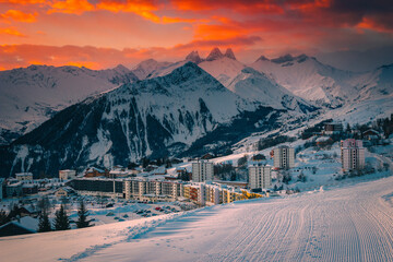 Alpine ski resort with buildings at sunrise, La Toussuire, France - obrazy, fototapety, plakaty