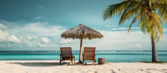 Fototapeten Tropical vacation with beach chairs umbrella and palms With copyspace for text © 2rogan