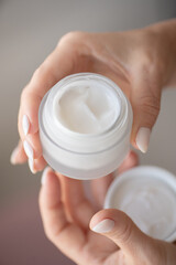 A woman's hands hold a white jar