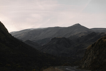 Dark Georgian mountains, road and sky with clouds
