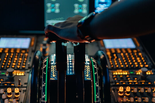 Hand of a pilot on the power levers of an airliner