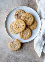 Overhead view of plate of snickerdoodle cookies on beige background.