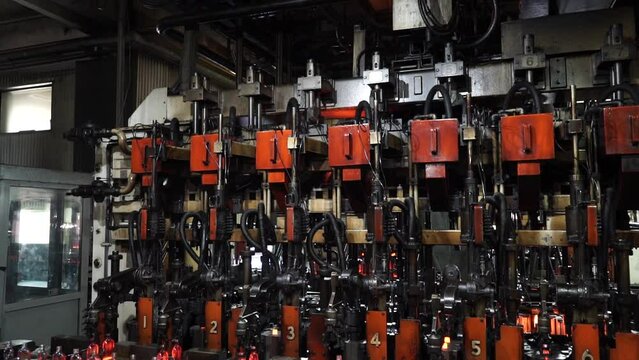 Automated line for the production of glass containers. The hot bottles are put on a moving conveyor. factory shop for the production of glass bottles and beverage. Glass recycling.