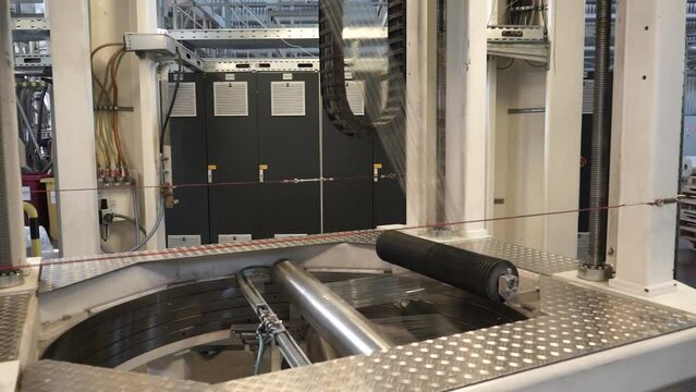 Roll of packaging film. Feeding unit of a modern packaging machine. Industrial line for the production of plastic packaging film. Factory for the production of packaging materials
