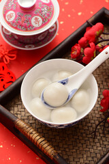A bowl of rice dumpling is placed on the red festive background of China-Chic Chinese style. The Chinese meaning in the picture is: Long life is boundless