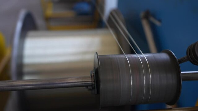 Coil winder machine with jackshafts copper wire drawing die. The mechanism of a braiding machine close-up. Modern equipment for making braids from metal alumino-copper wire.