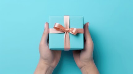 Hand holding gift box on pastel blue background