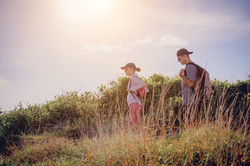 Happy young couple climbs to the top in the mountains near the ocean