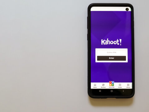 Harish, Israel - June 10 2021: Kahoot app launch screen with logo on the display of a black mobile smartphone isolated on white background. Top view flat lay with copy space.